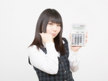クリニックの開業費用を電卓で計算する女性